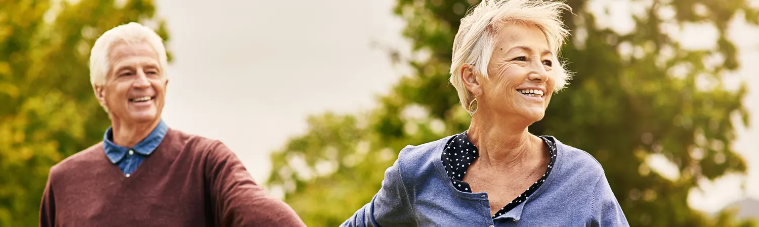 An older couple laughing outdoors