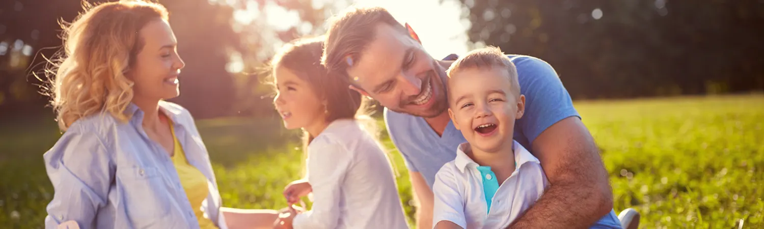 A family laughing together on the grass